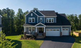 Charming suburban house in Holly Springs, NC, featuring a large driveway and porch.